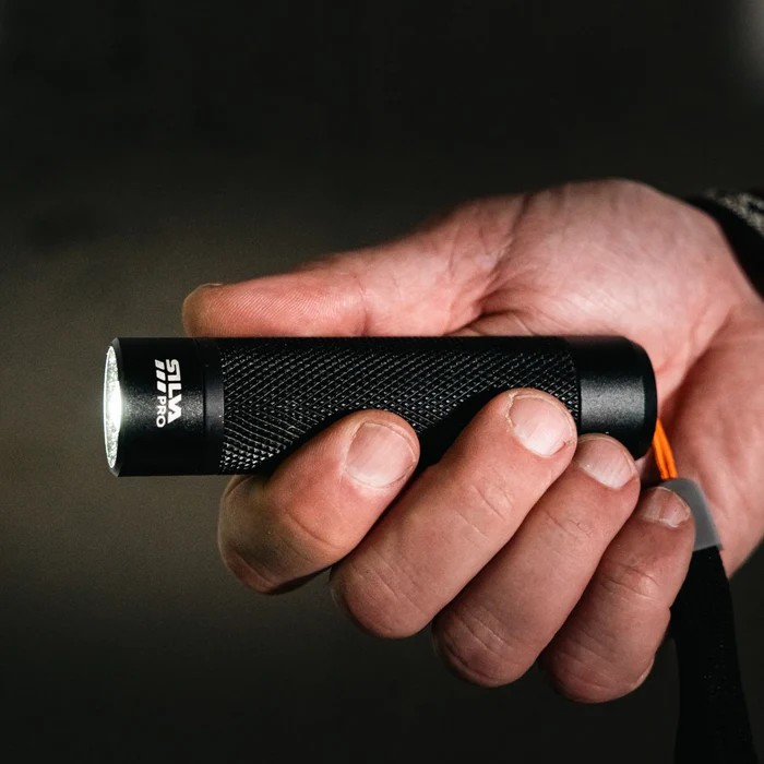 rode-kors-SILVA-Gear-lykt En hånd holder en liten lommelykt som lyser