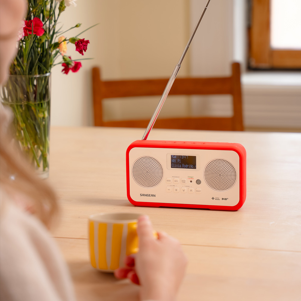 rode-kors-radio-sangean-bord Rød liten radio på bord inne